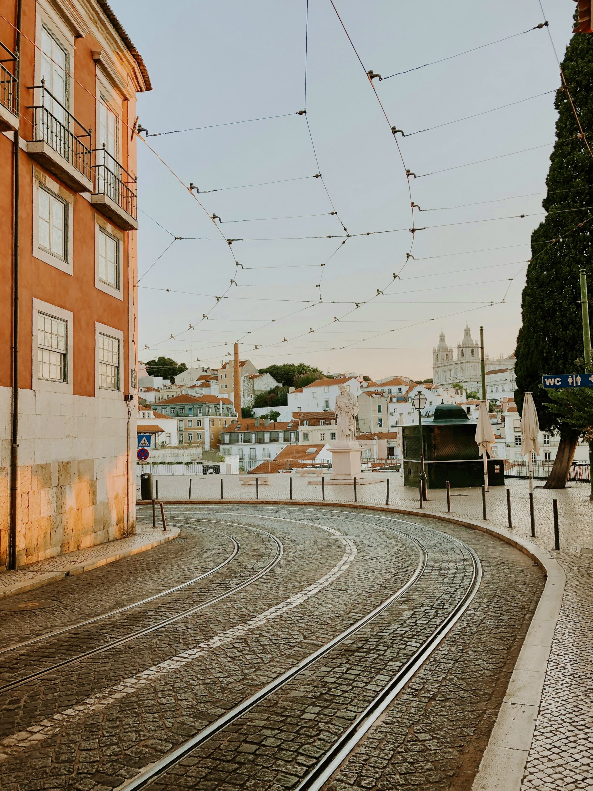 Cobblestone road with tram tracks on a calm Lisbon summer evening.